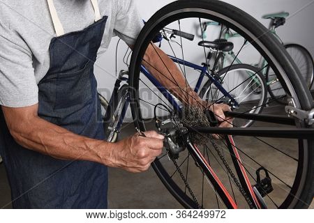 Bicycle Repair. A Bike Tech making adjustments to the derailleur in his workshop.