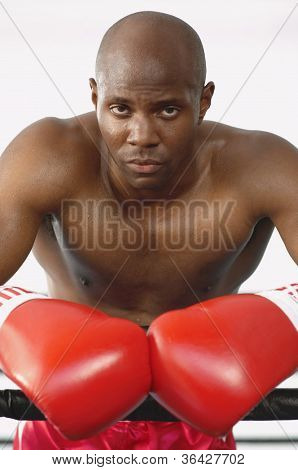 Portrait of a serious African American boxer standing by the boxing ring