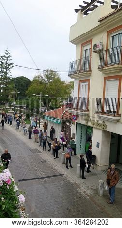 Crowd Of People Queuing Outside Bank On Restricted Opening Day
