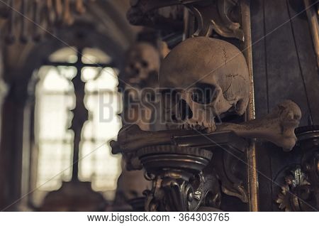 Kutna Hora, Czech Republic, May 14, 2019: Close-up Human Scull With Bone In Mouth And Crucifixion Of