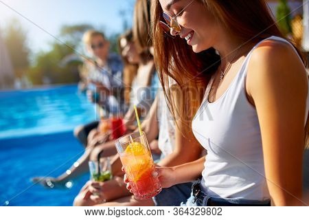 Pretty Woman Relax With Fresh Colorful Cocktail Glass Sitting By Swimming Pool On Sunny Summer Day W