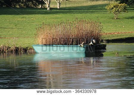 A Fibreglass Dinghy Boat Moored On A Small Lake.