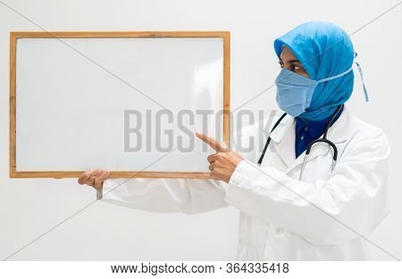 Muslim female doctor with blank whiteboard