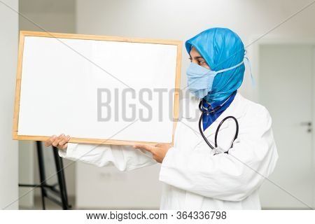 Muslim female doctor with blank whiteboard