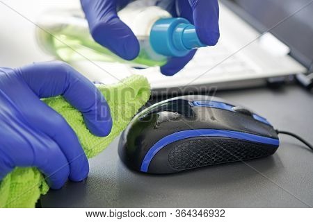 A Man In Blue Gloves Wipes A Dirty Mouse With A Rag. Cleaning Computer Mouse. Removing Microbes With