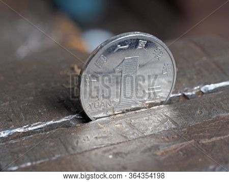 Yuan Coin Clamped In A Metal Vise. Currency Under The Onslaught, The Concept Of Financial Problems A