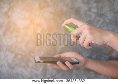 Closeup Woman Hands Using Spray Alcohol Sanitizer Cleaning Screen Smartphone, To Prevent The Virus A