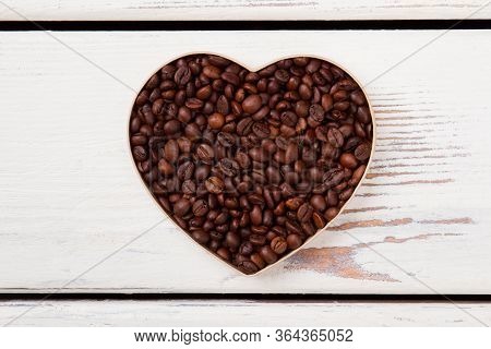Flatlay Heart Shaped Roasted Coffee Beans. White Wood On Background.
