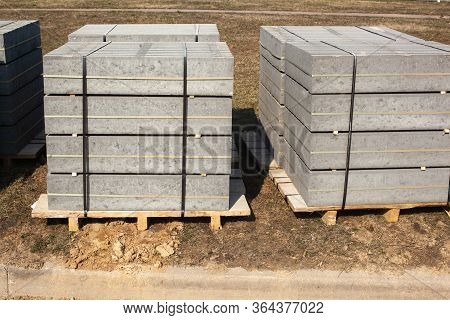 Piled Concrete Curbstones. Construction Material For Road Construction Works. Construction Backgroun