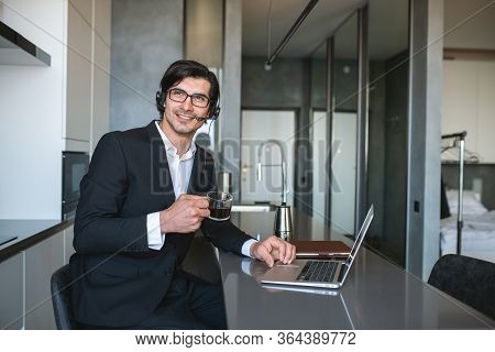 Businessman Works From Remote At House With A Laptop Due To Coronavirus Quarantine.