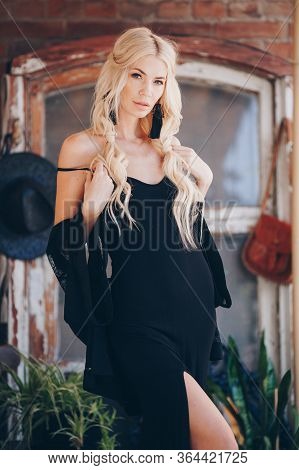 Portrait Of Beautiful Young Blonde In The Black Clothing Of Style Of Boho In A Summer Arbour