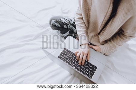 Remote Work At Home, Female On The Bed During The Day Working With A Laptop, Looking On The Screen.