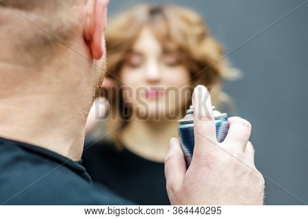 Hairdresser Is Using Hairspray On Clients Hair At Salon. Closeup Of Hairdressers Hands Are Using Hai