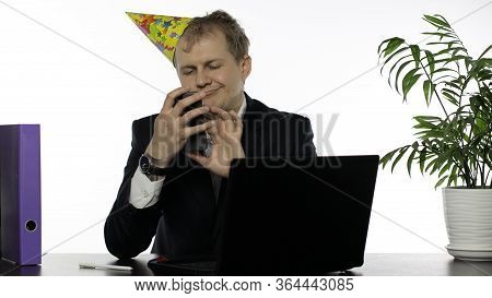 Drank Young Clerk Man Sitting At The Office Desk With A Hangover Using Mobile Phone. Emotions. Dishe