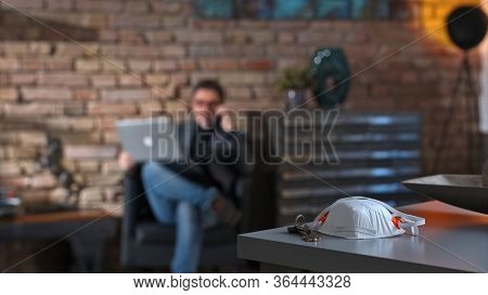 Covid-19 virus danger - Businessman working at safety of home office leaving virus protective mask on desk.