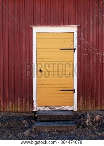 An Old Yellow Door Of A Wooden Red Building At A Fishing Village In The Northern Finland.