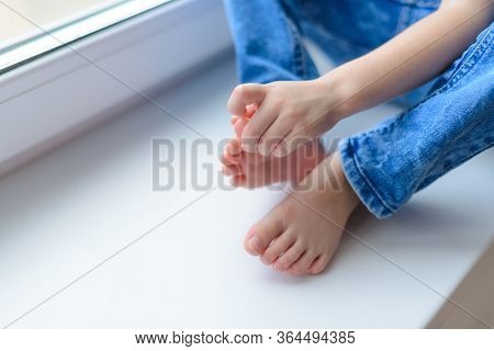 The Child Picks His Toenails And His Fingernail On His Big Toe Is Broken. Children's Habit. Emotiona