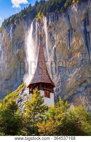 Autumn View Of Lauterbrunnen Staubbach Falls Waterfall And Church Tower In Swiss Alps, Jungfrau Regi