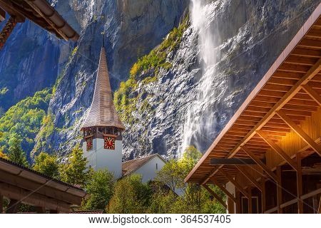 Autumn View Of Lauterbrunnen Staubbach Falls Waterfall And Church Tower In Swiss Alps, Jungfrau Regi