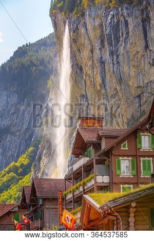 Lauterbrunnen, Switzerland - October 10, 2019: Town Street View With Staubbach Falls Waterfall In Al