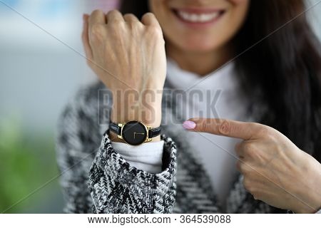 Close-up Of Female Hand Wearing Luxury Wristwatch. Equipment Showing Time. Smiling Woman Pointing Wi