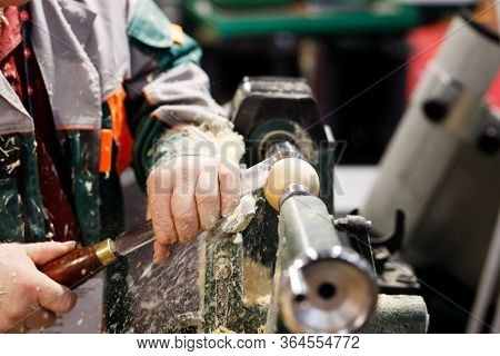 Carpenter At Work On A Woodturning Lathe Machine. Selective Focus.
