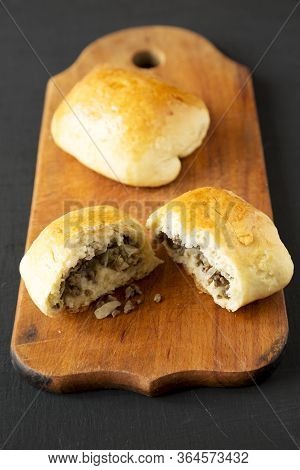 Home-baked Beef Russian Bierocks On A Rustic Wooden Board On A Black Surface, Side View. Close-up.
