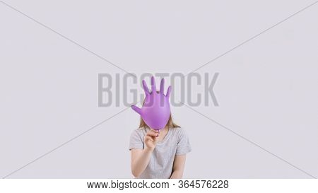 Young Sad Girl Play With Protective Medical Glove. Teenager With Glove Inflated Like Balloon. Quaran