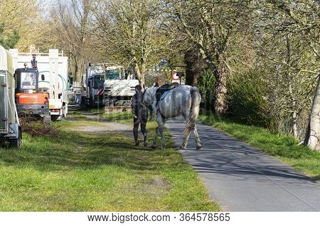 Sint Gillis Waas, Belgium, April 4, 2020, Man With Horse On Hand Must Pass Through Obstacle Of Vehic