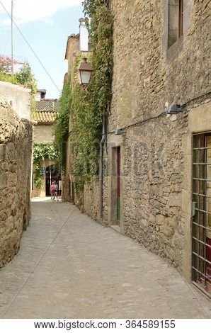 Peratallada, Spain - July 25, 2017: Girls At Narrow Stone Alley Of The Medieval Village Of Peratalla