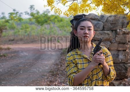 Portrait The Farmer Asea Woman Wearing A Yellow Shirt Hand Holding Old Revolver Gun In The Farm, You