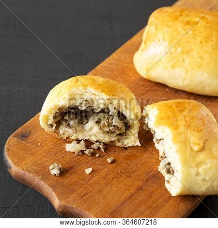 Home-baked Beef Russian Bierocks On A Rustic Wooden Board On A Black Surface, Side View. Close-up.