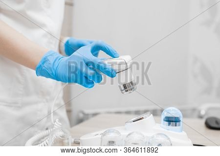 Trichoscope In The Hands Of A Doctor Close-up. Doctor In Signets Holds Trichoscope