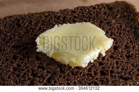 Ghee On A Piece Of Coarse Rye Bread. Selective Focus.