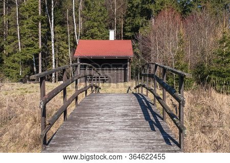 Fishermans House With A Wooden Pedestrian Bridge On A Tiny Island In The Middle Of The Lake. Autumn 