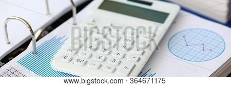 White Caculator With Business Chart Lie On The Office Table Background Closeup. Financial Education 