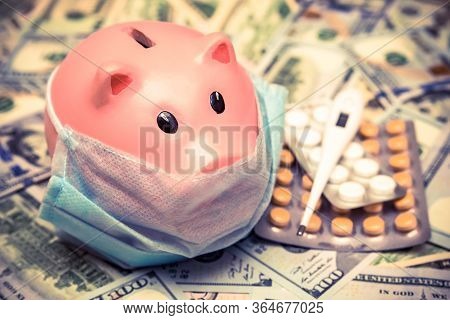 Piggy Bank In A Mask On A Background Of American Currency.the Concept Of Coronavrius Epidemic