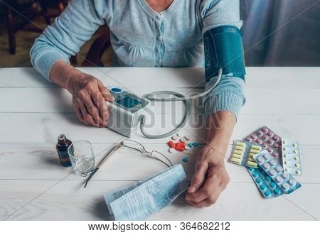 Senior Wrinkled Hands With Blood Pressure Measure Cuff, Medicine Bottle, Glass, Colorful Pills, Ther