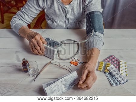Senior Wrinkled Hands With Blood Pressure Measure Cuff, Medicine Bottle, Glass, Colorful Pills, Ther