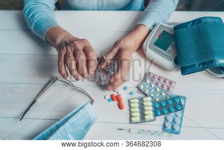 Senior Wrinkled Hands With Blood Pressure Measure Cuff, Medicine Bottle, Glass, Colorful Pills, Ther
