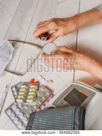 Senior Wrinkled Hands With Blood Pressure Measure Cuff, Medicine Bottle, Glass, Colorful Pills, Ther