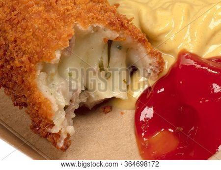 Partly Eaten Brown Crusty Dutch Kroket With Mustard And Ketchup Isolated On A White Background