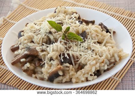 Tasty Appetizing Risotto On A White Plate On A Wooden Table