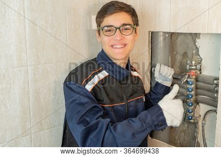Portrait Of Caucasian Smiling Plumber At Work. Worker In Uniform. Handyman Working On Central Heatin