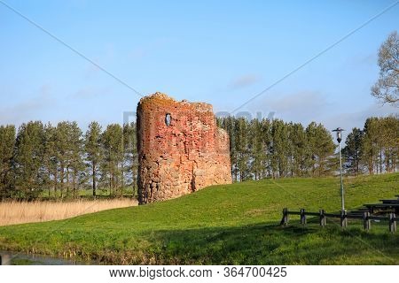 Old Collapsed Tower Of A Water Mill On The River Bank On A Clear Sunny Day, Piltene, Latvia