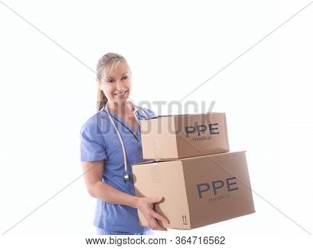 Smiling Female Nurse Or Healthcare Worker Holding A Delivery Of Much Needed Boxes Of Ppe Or Other Cr