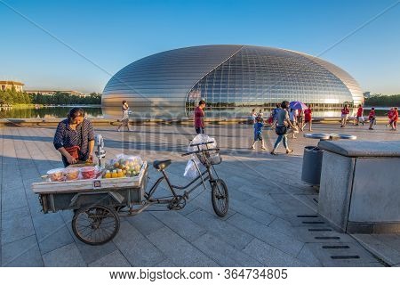 Beijing, China - July 12, 2016: Woman Selling Fruits On A Bicycle Cart In Front Of The National Cent