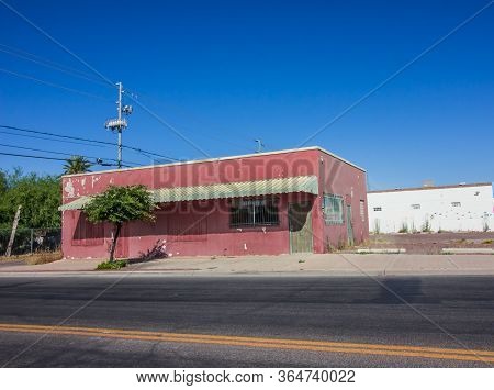 Abandoned Pink Commercial Building With Boarded Up Windows