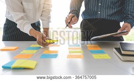 Young Business Workers Posting With Sticky Notes Stickers Reminders  Creative Brainstorming At Board