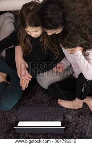 Mother Doing Lessons With Children On A Tablet